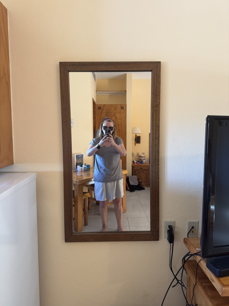 Mirror selfie in the casita in Loreto , wooden-framed mirror reflecting the open-plan room with tile floors and a dining table