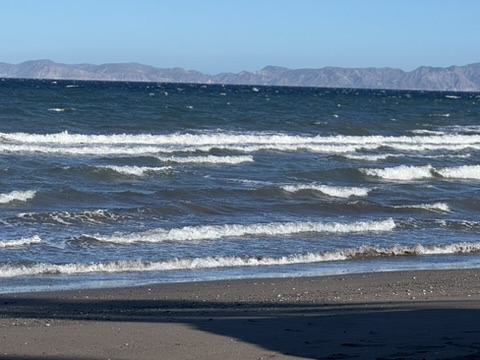 Gentle waves rolling in on the beach at Loreto, Sea of Cortez with mountains beyond